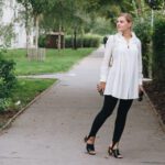 BlackAndWhite Outfit in weißer Tunkia-Bluse von Lineight, Mini-Pochette von Louis Vuitton, Jeggings mit Fußschlaufen, Mules mit Goldabsatz und runder Sonnenbrille
